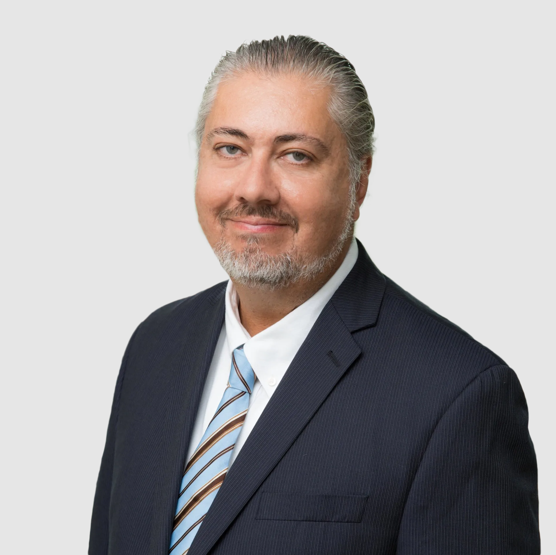 A man in a suit and tie is standing in front of a window.