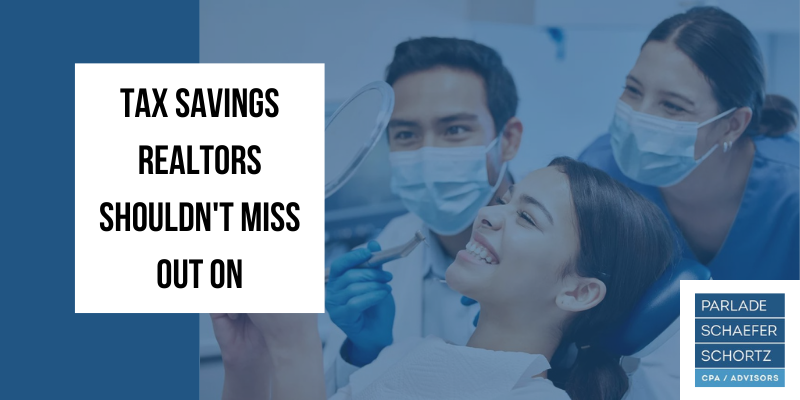 A woman is getting her teeth examined by a dentist and a nurse.