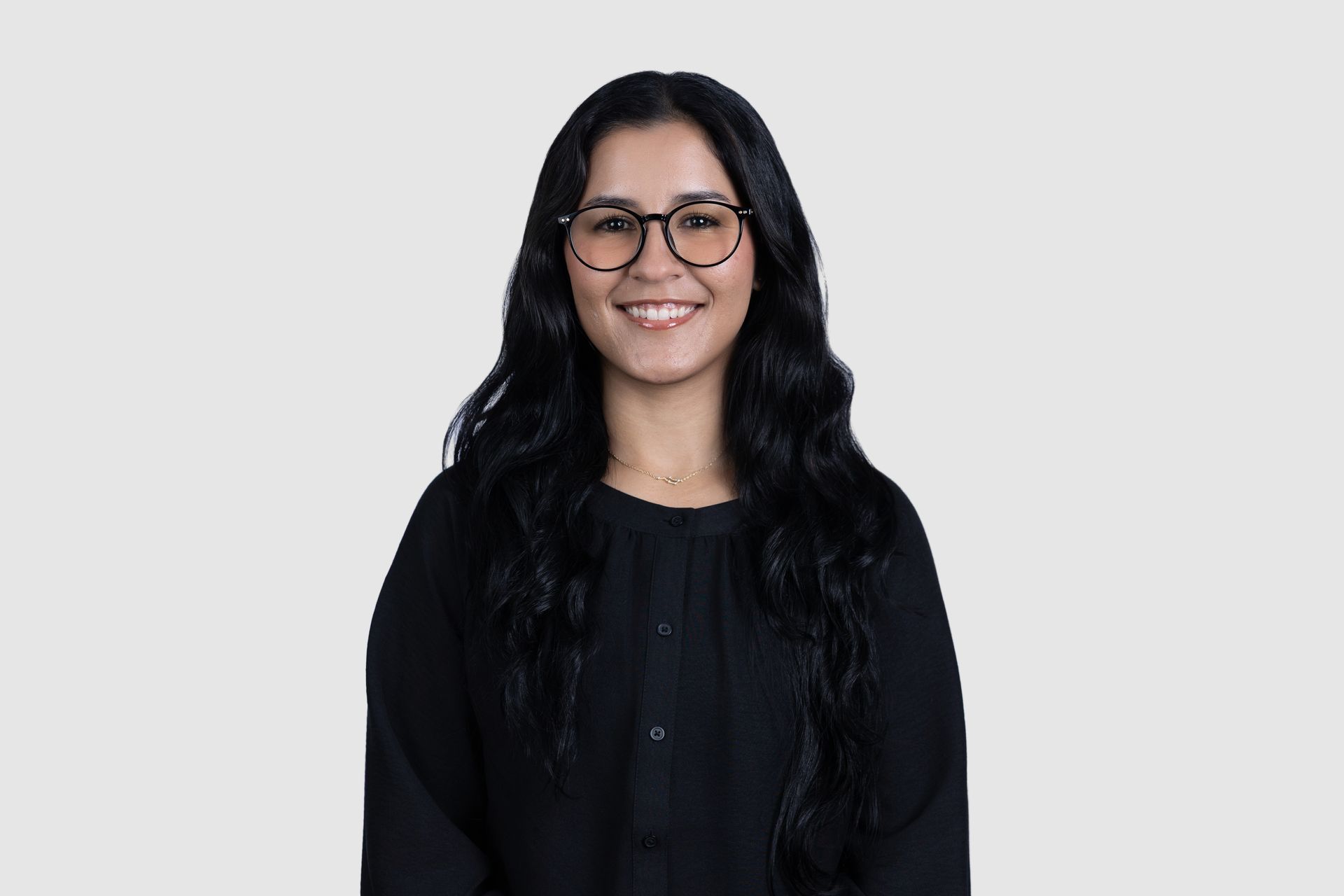 A man in a suit and tie is sitting in front of a window.