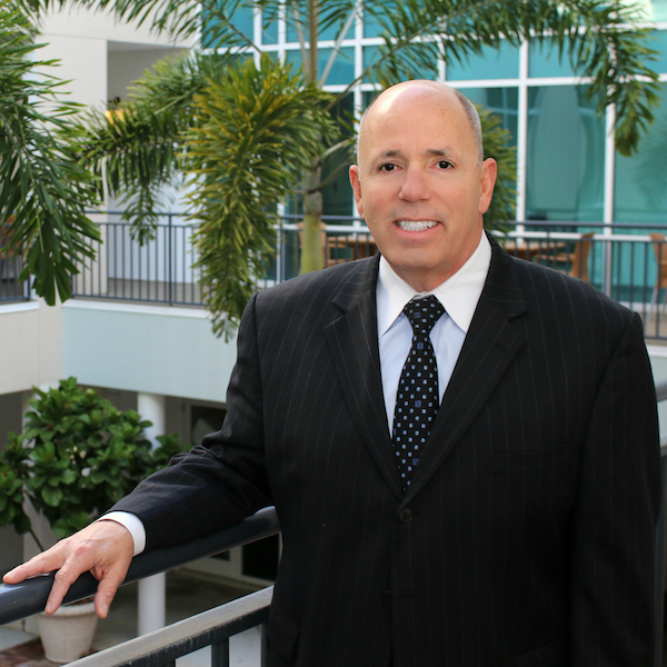 A man in a suit and tie is leaning on a railing