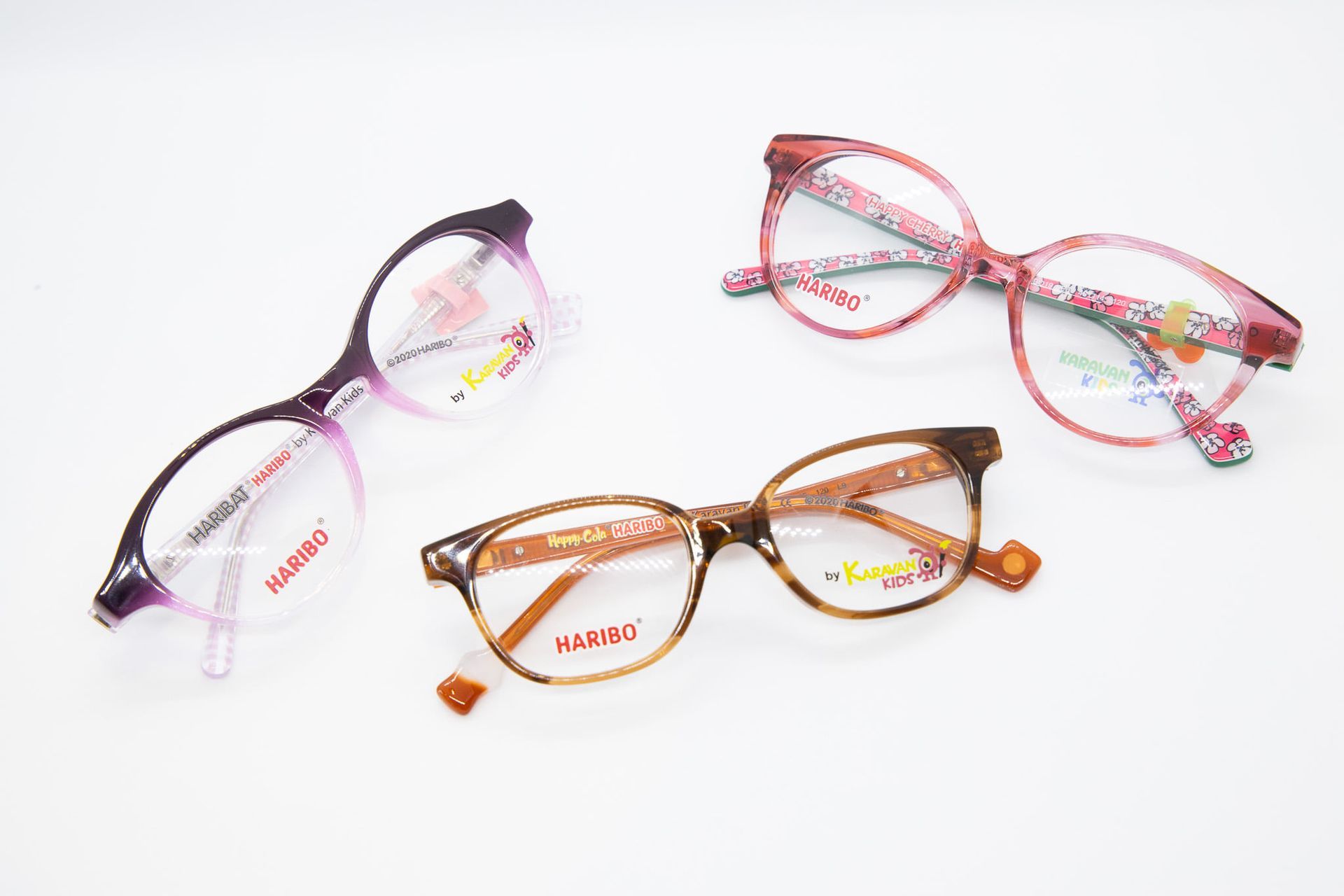 Trois paires de lunettes sont assises l'une à côté de l'autre sur une surface blanche.