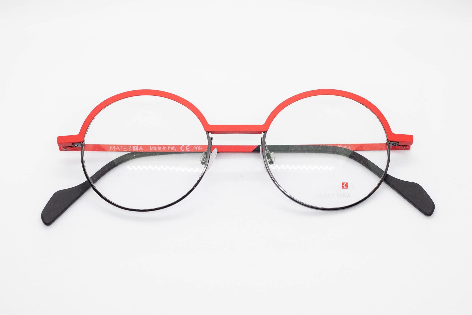 Une paire de lunettes rondes rouges et noires sur fond blanc.