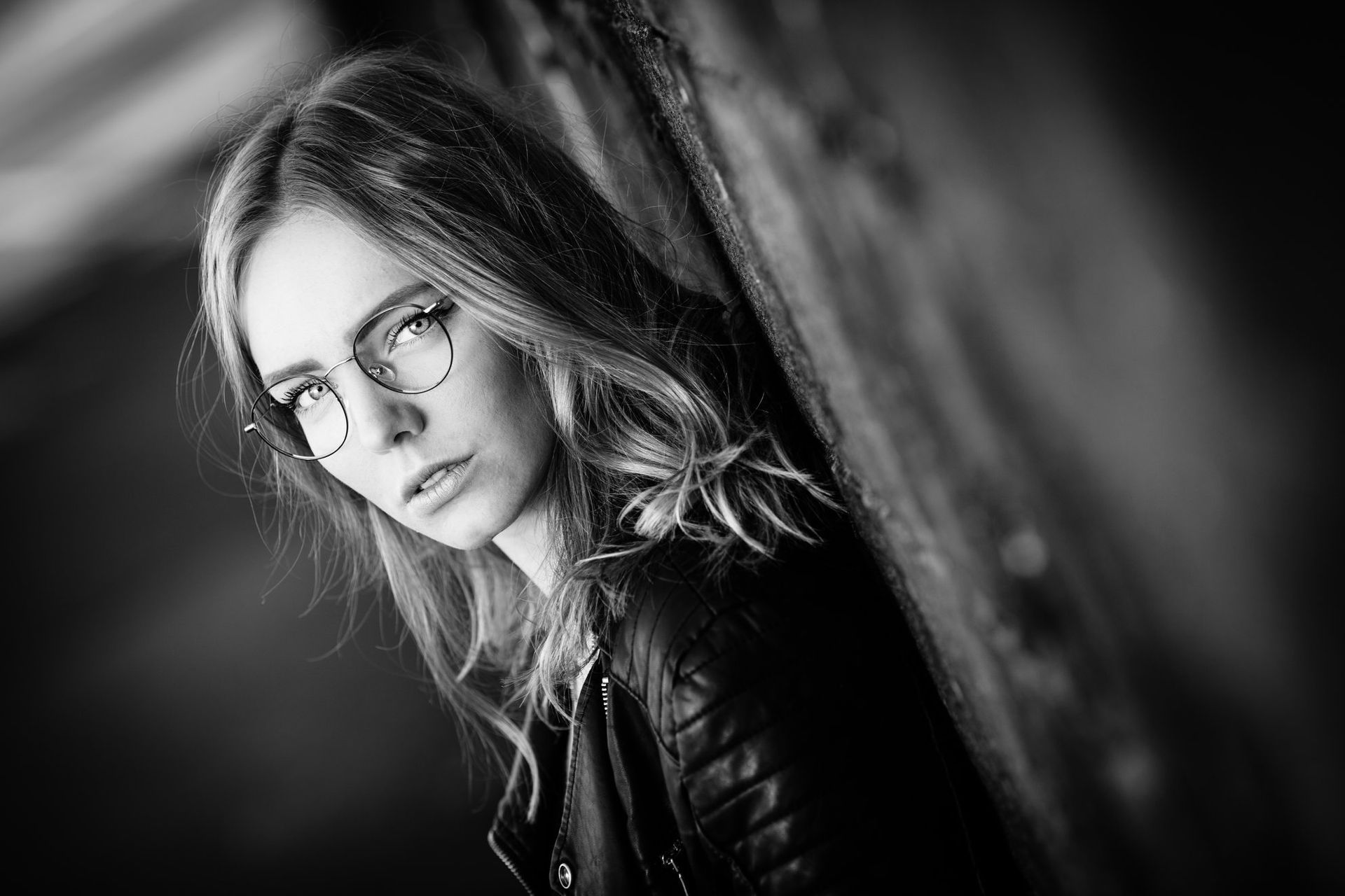 Photo en noir et blanc d'une femme portant des lunettes et une veste en cuir.