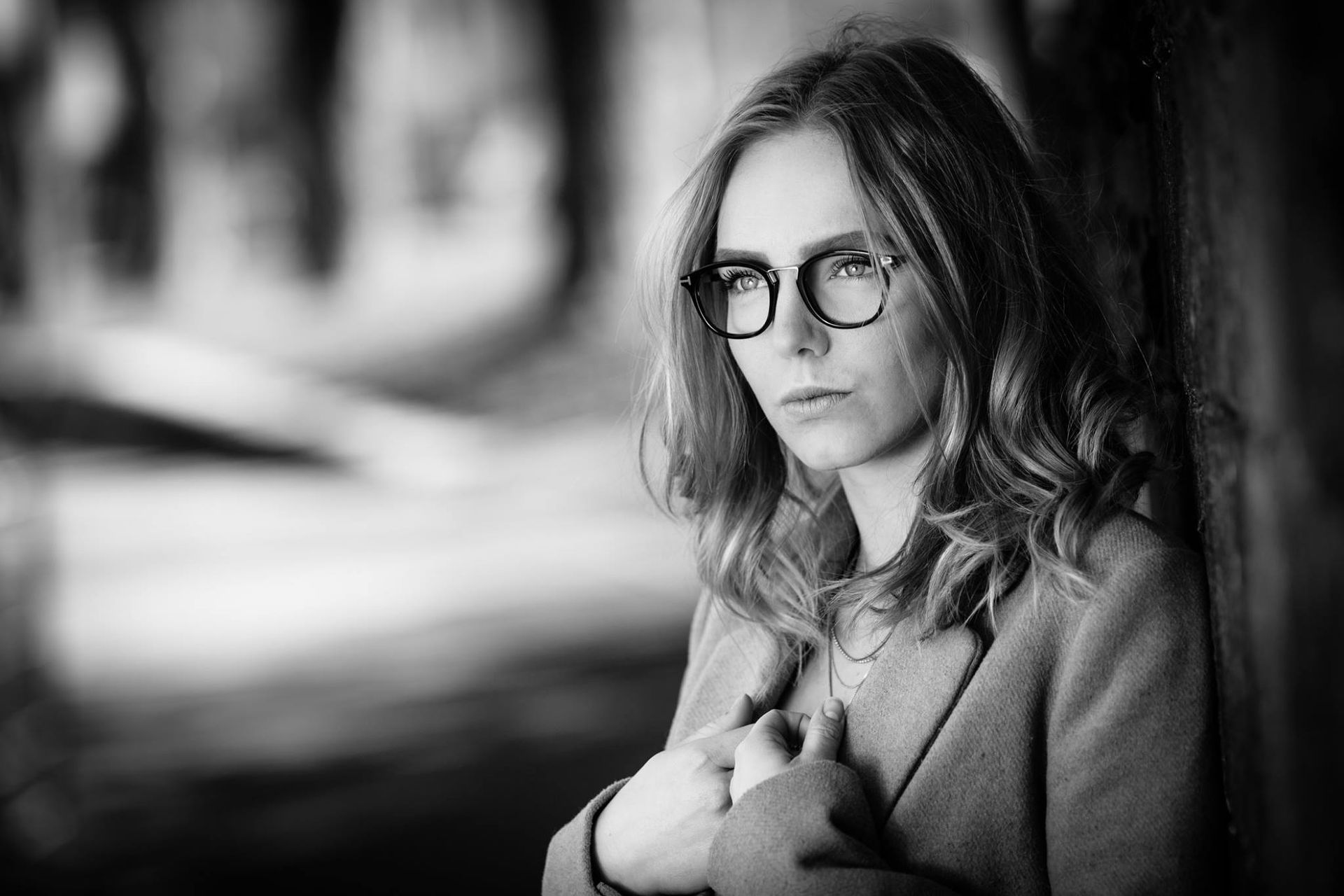 Photo en noir et blanc d'une femme portant des lunettes et un manteau.