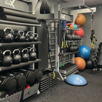 A gym filled with lots of exercise equipment including kettlebells