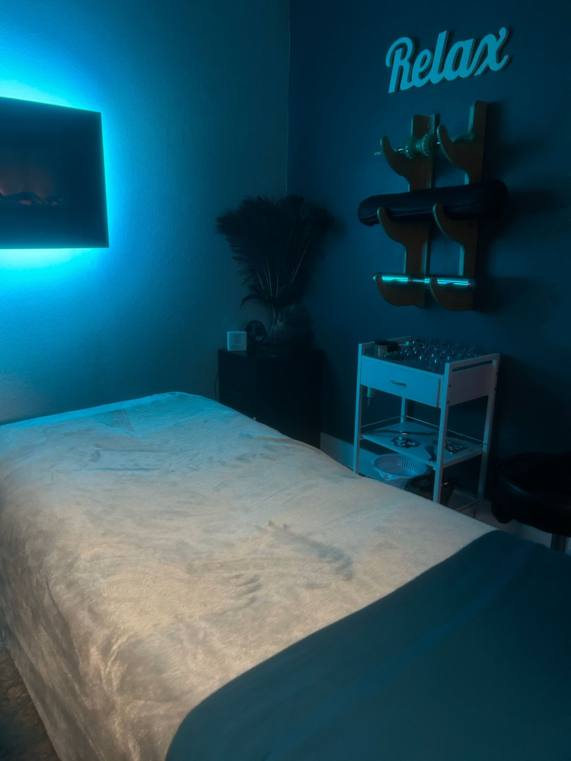 A massage table in a room with a sign that says relax.