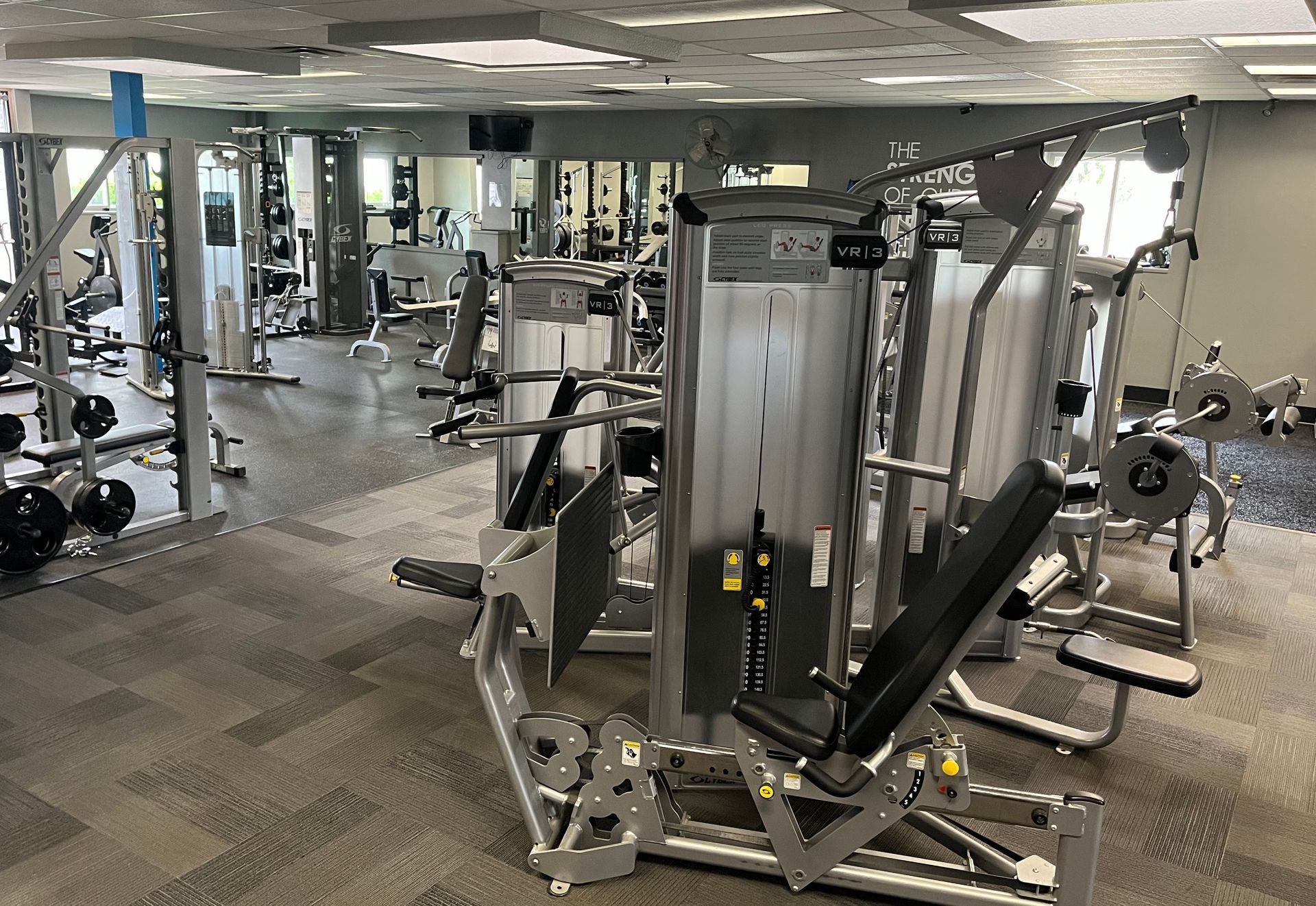 A large gym filled with lots of exercise equipment.