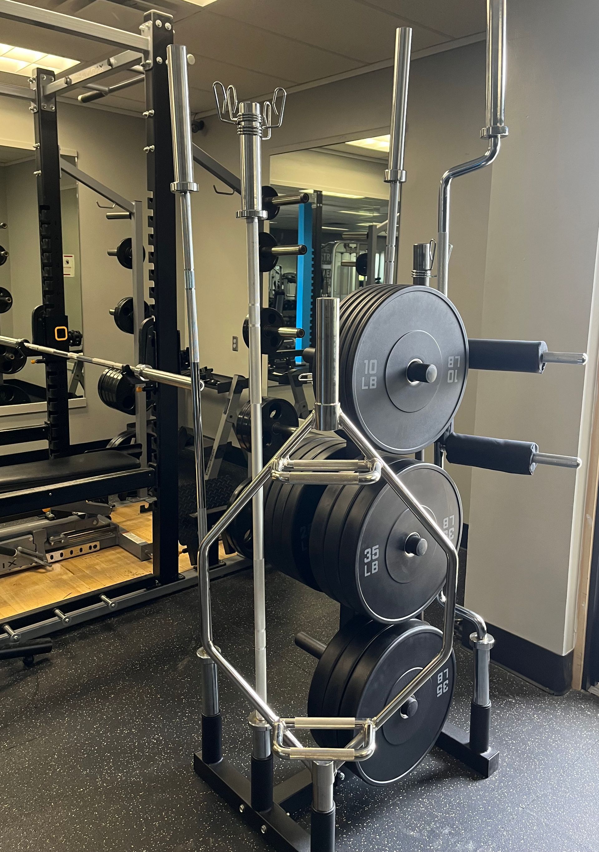 A gym with a barbell rack filled with plates.