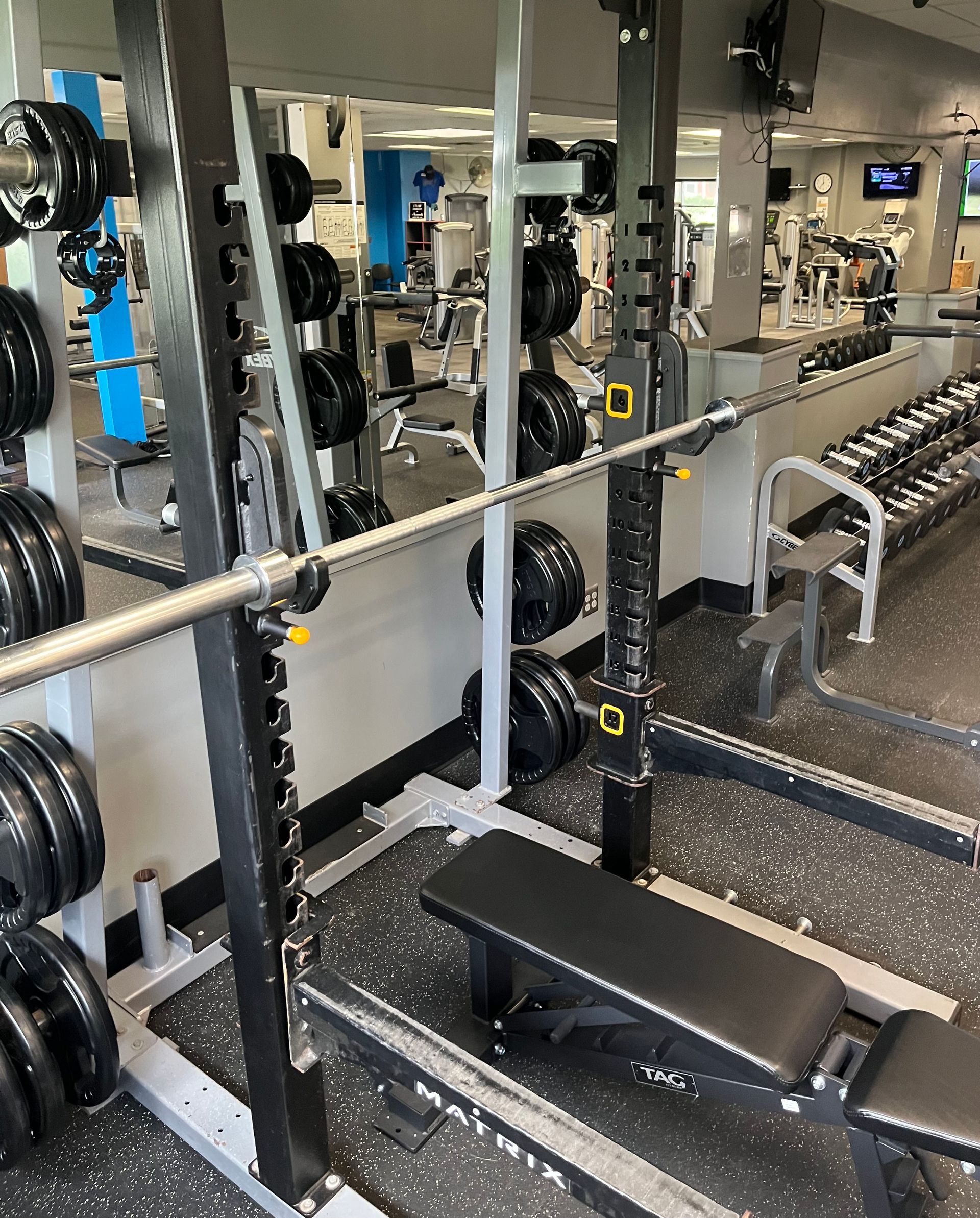 A gym filled with lots of dumbbells and benches.