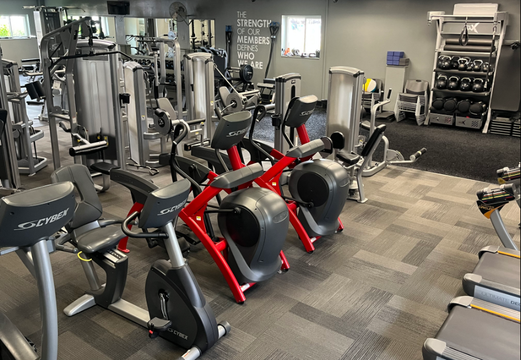 A gym filled with lots of exercise equipment including treadmills and bikes.