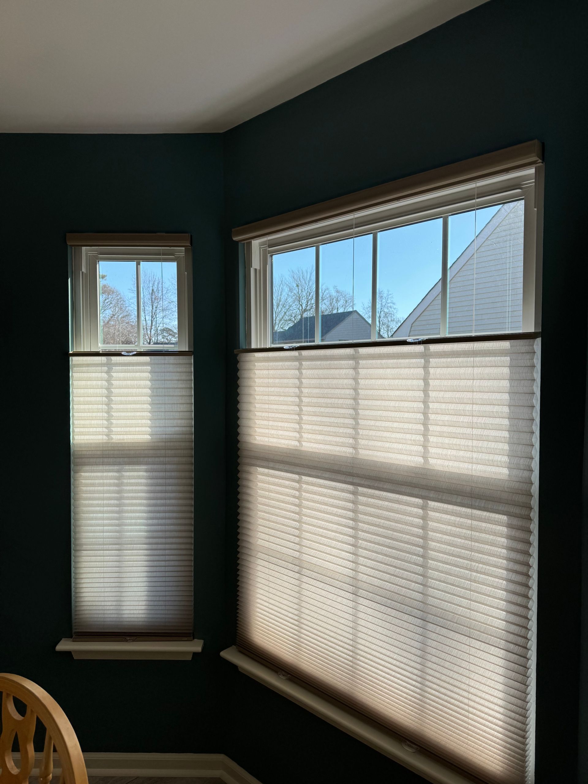 A room with two windows with blinds on them