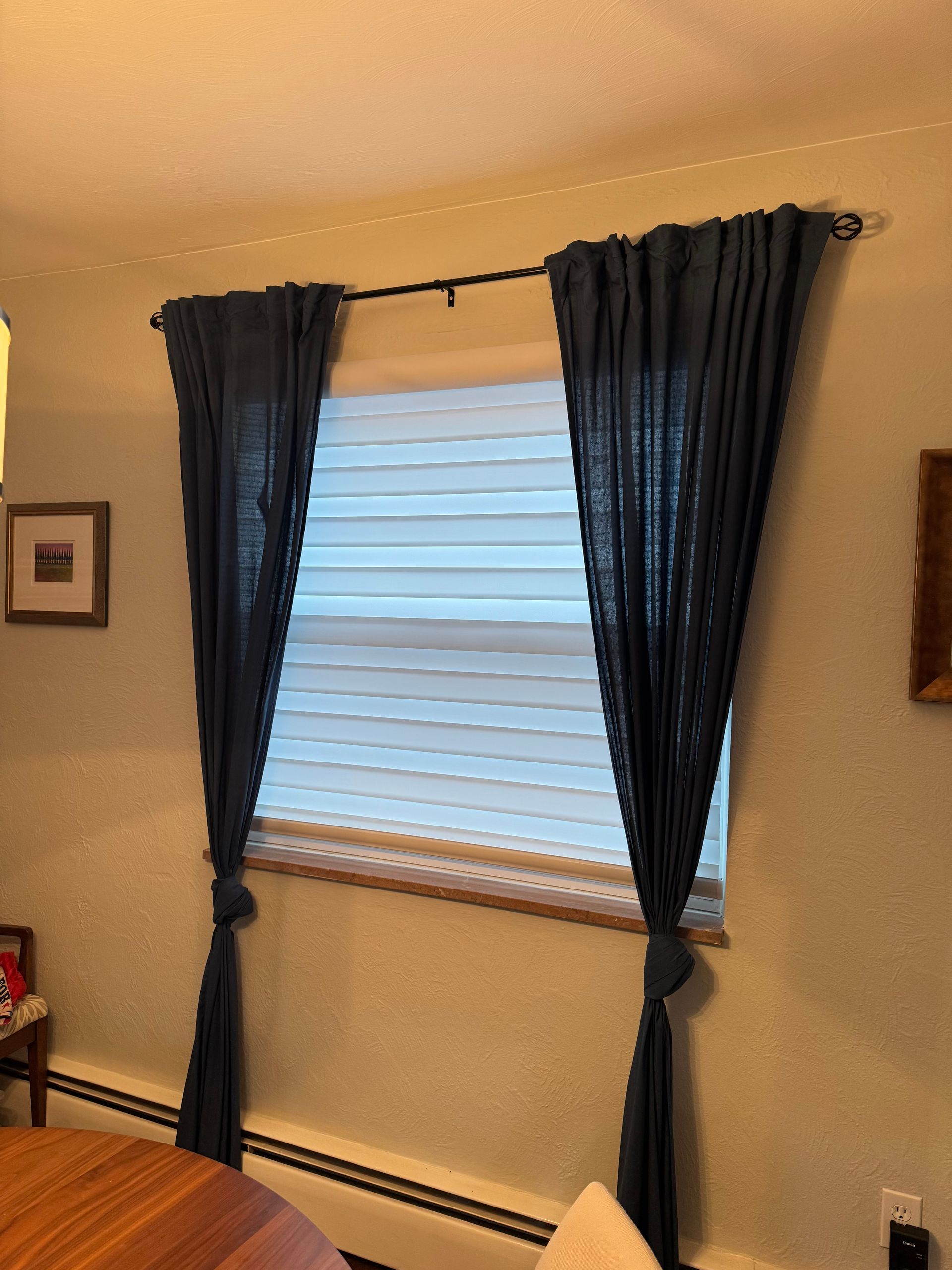 A window with blue curtains and blinds in a room