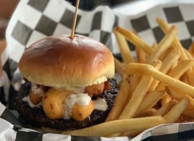 A close up of a hamburger and french fries in a basket