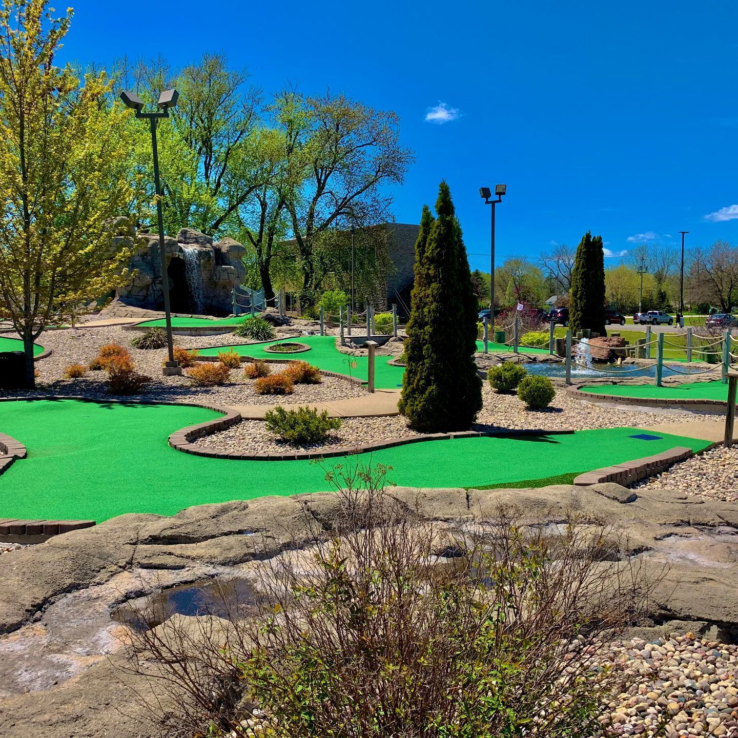 A miniature golf course in a park on a sunny day