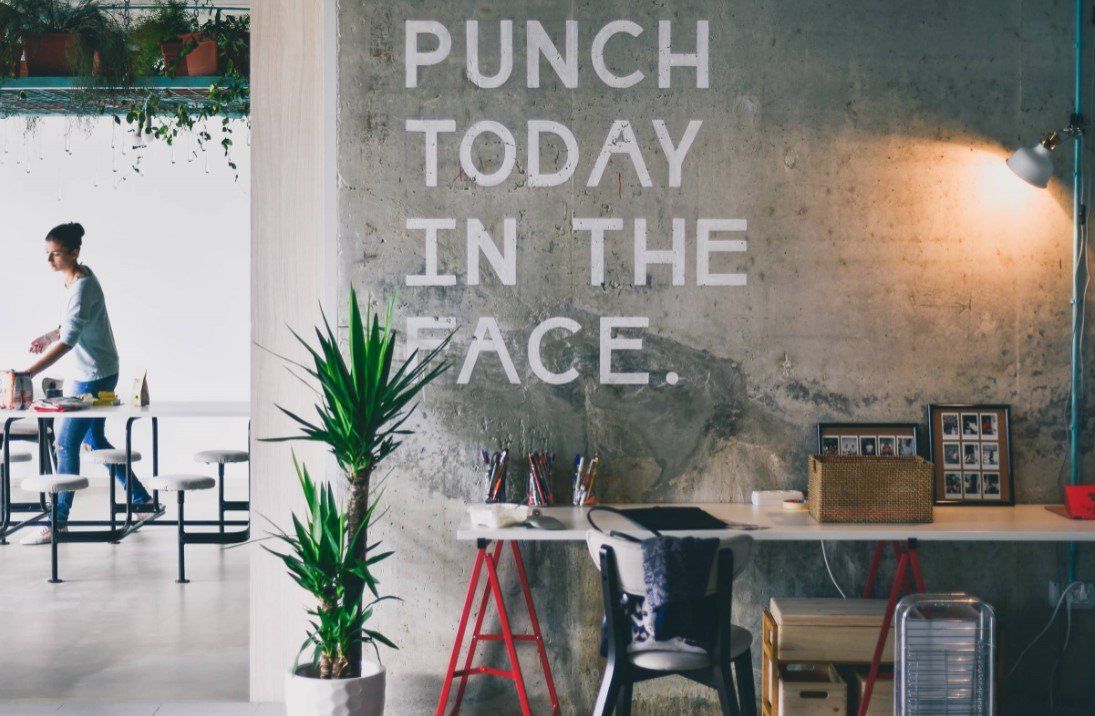 Picture of an office area with a sign that reads Punch Today in the Face