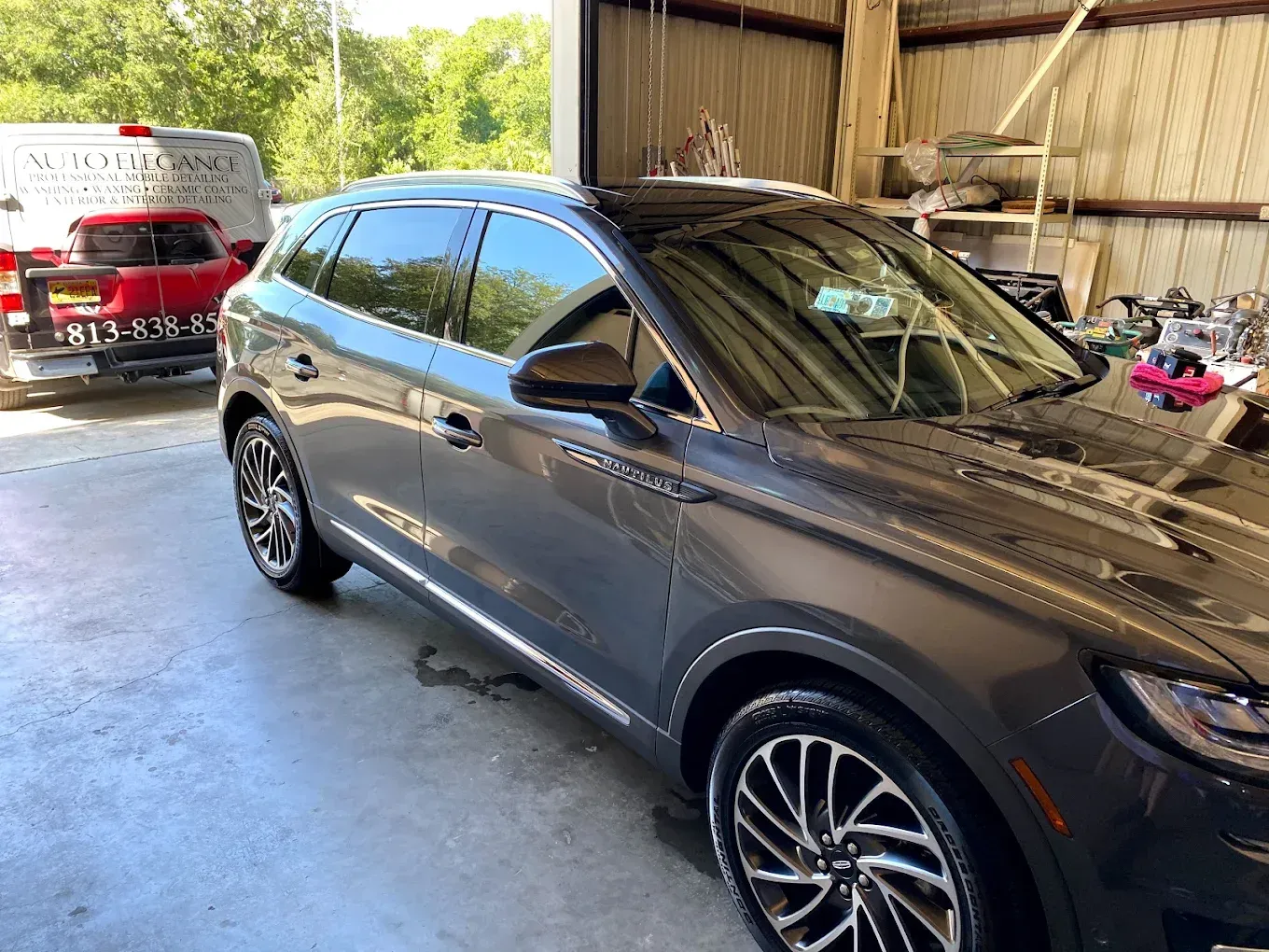 Dark gray Lincoln Nautilus SUV parked in a shop, wet after washing.