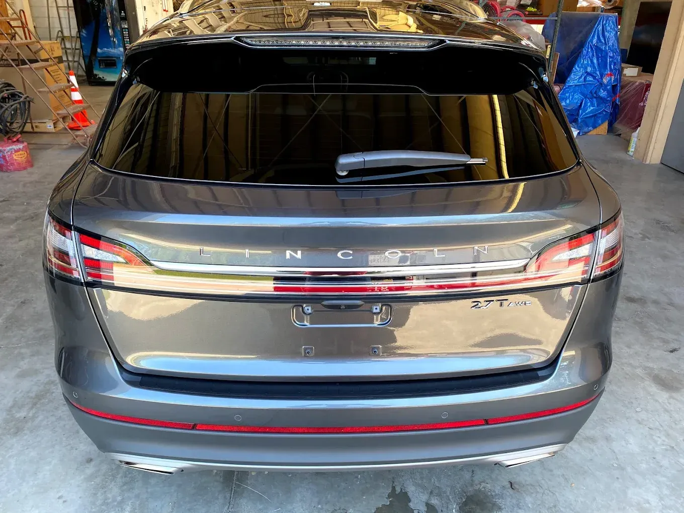 Rear view of a gray Lincoln SUV with tinted windows and a red accent stripe.