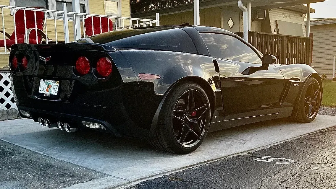 Black Corvette sports car parked on concrete.
