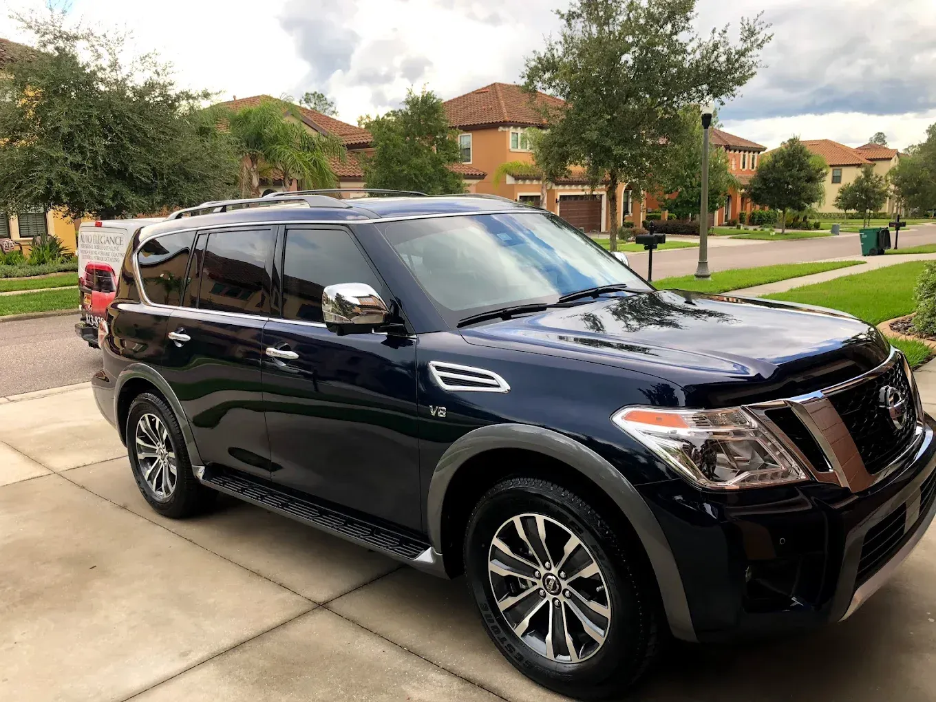 Dark blue Nissan Armada SUV parked on a driveway, with chrome accents, in a suburban setting.