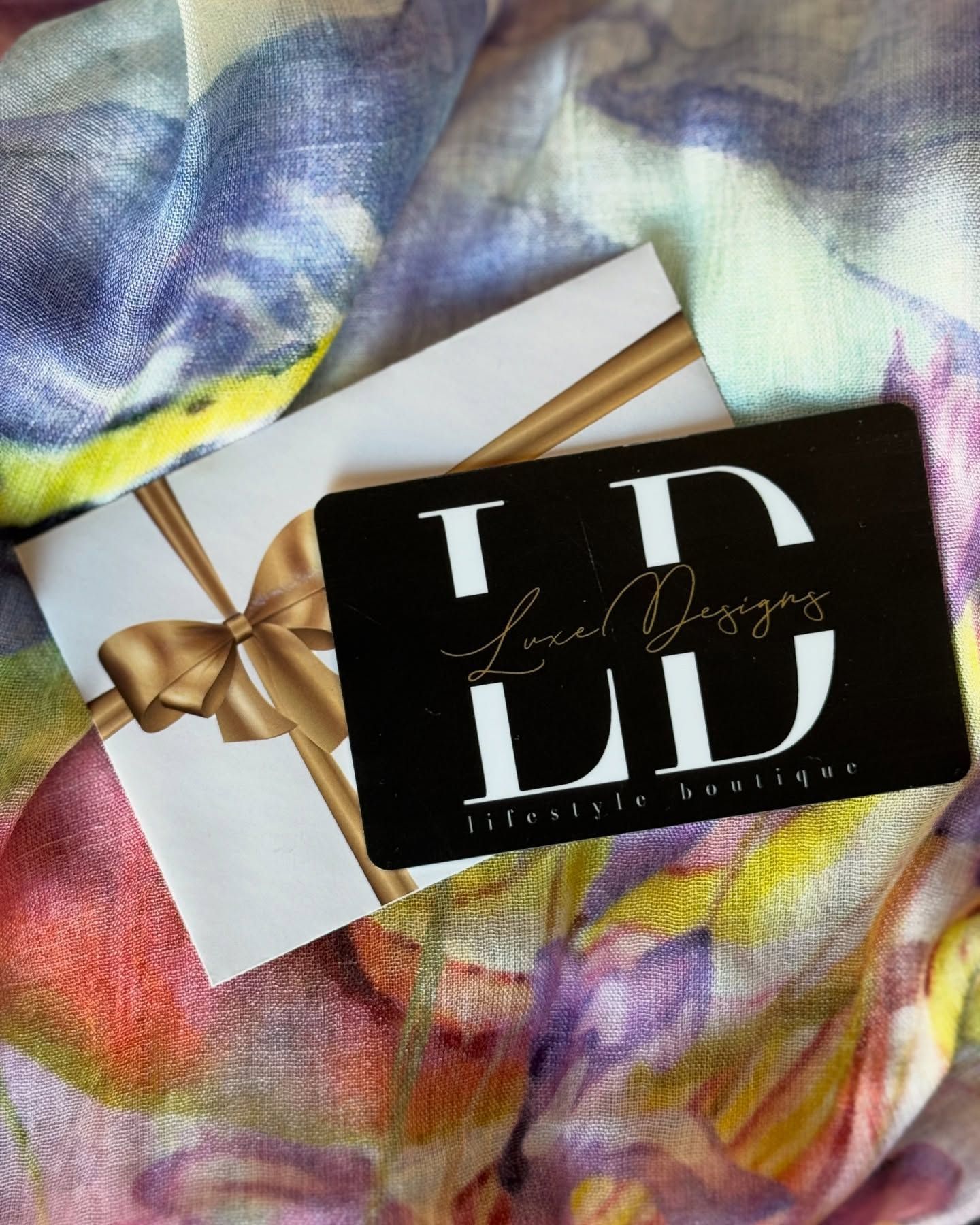 Gift card with gold ribbon, on a colorful scarf, with