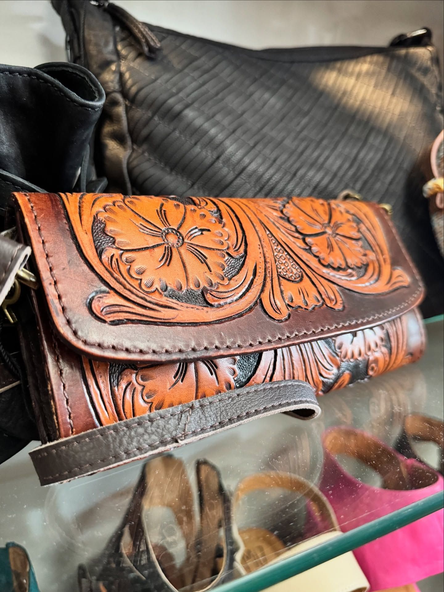 Brown leather wallet with floral tooled design.