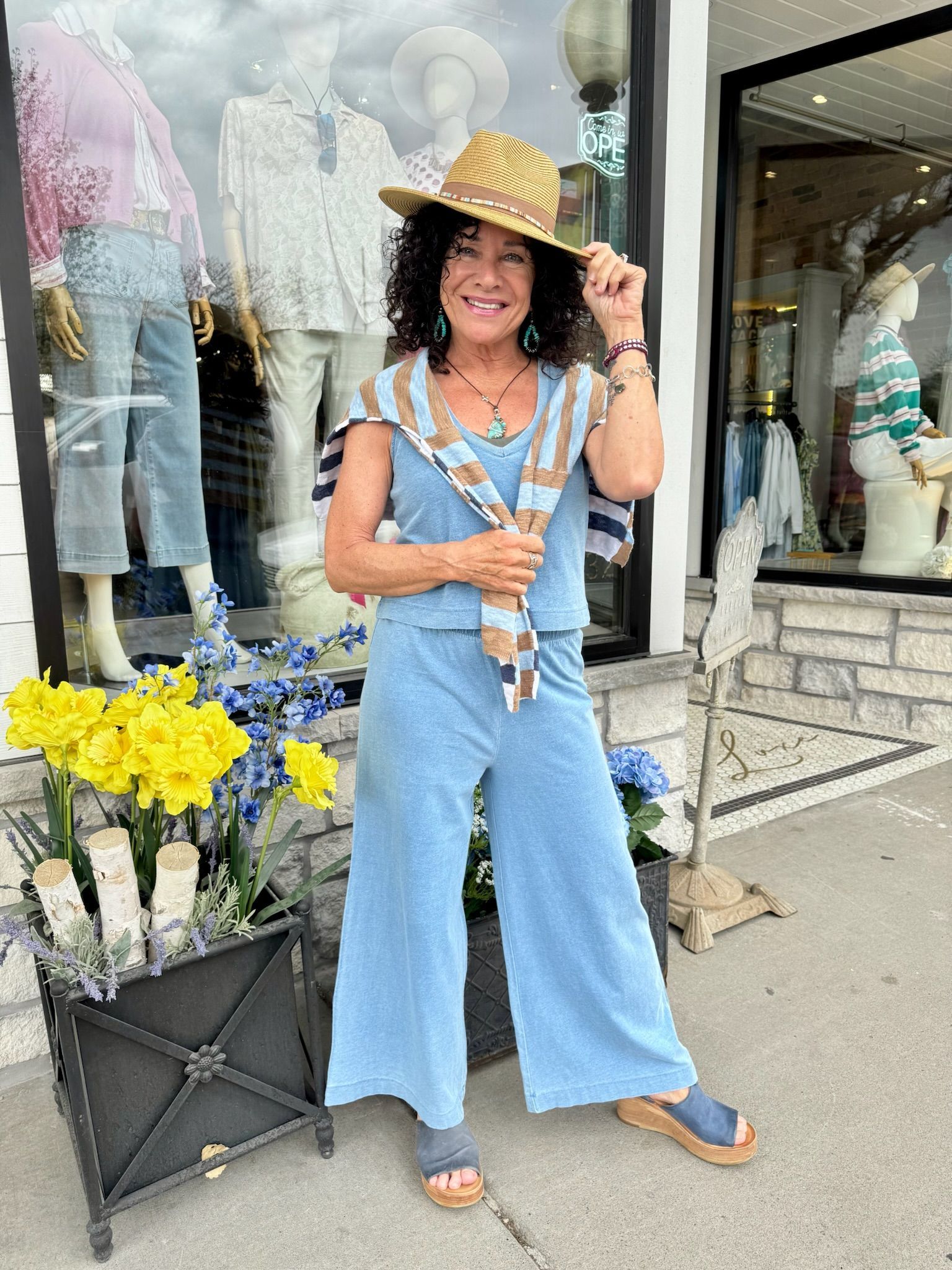 White lace dress and straw hat on a mannequin in a shop.