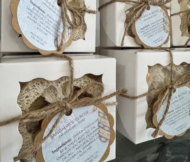 Stacked boxes with cut-out windows, containing product and tied with twine and tags.