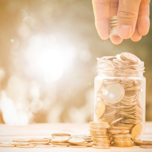 Greg Harkerss in a blue shirt is smiling with his arms crossed