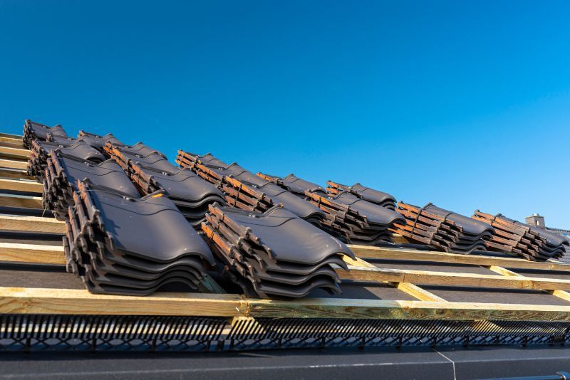 a stack of tiles sitting on top of a wooden roof The Amish Roofer.