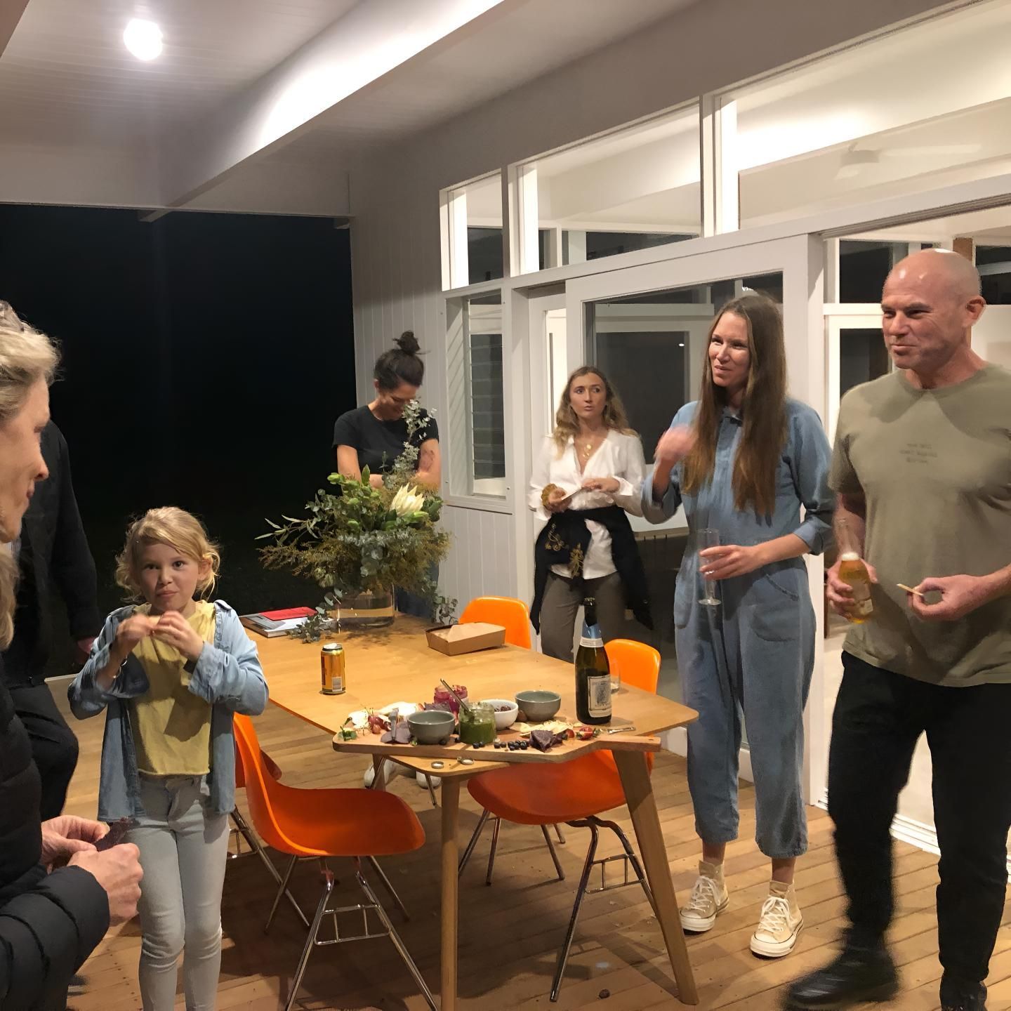 A Group of People Standing Around a Table With a Bottle of Wine on It — Limited Access Excavation In Suffolk Park, NSW
