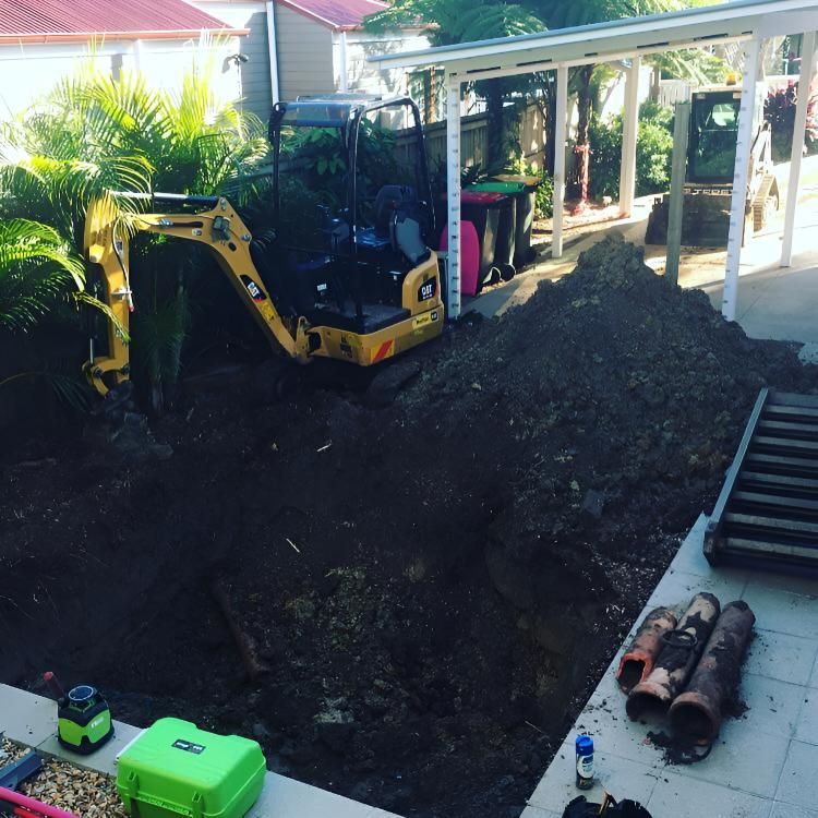 A Yellow Cat Bulldozer is Digging a Hole in a Backyard — Limited Access Excavation In Suffolk Park, NSW