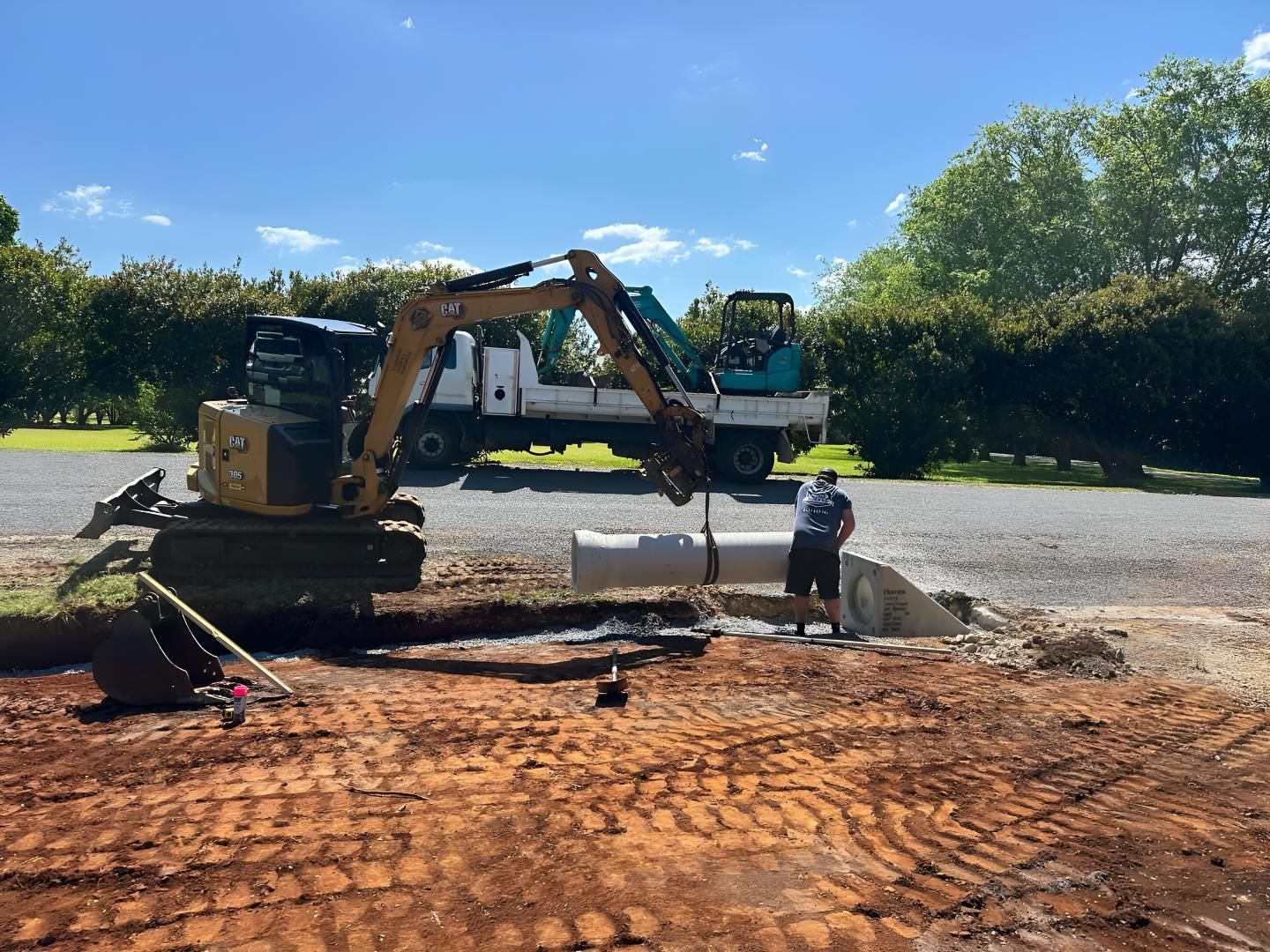 A Man is Standing Next to an Excavator in a Dirt Field. — Limited Access Excavation In Lismore, NSW