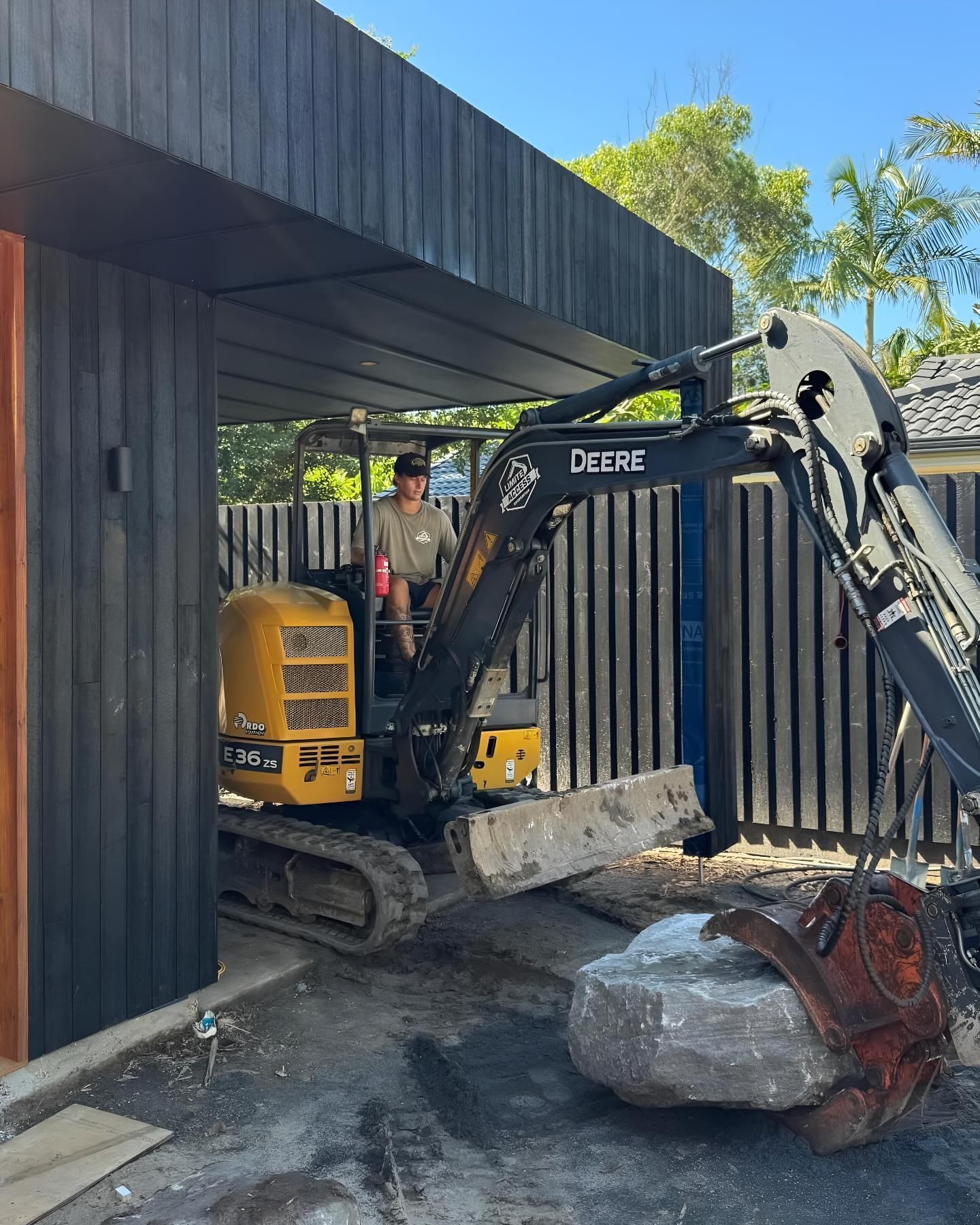 A Deere Excavator is Parked in Front of a Building — Limited Access Excavation In Evans Head, NSW