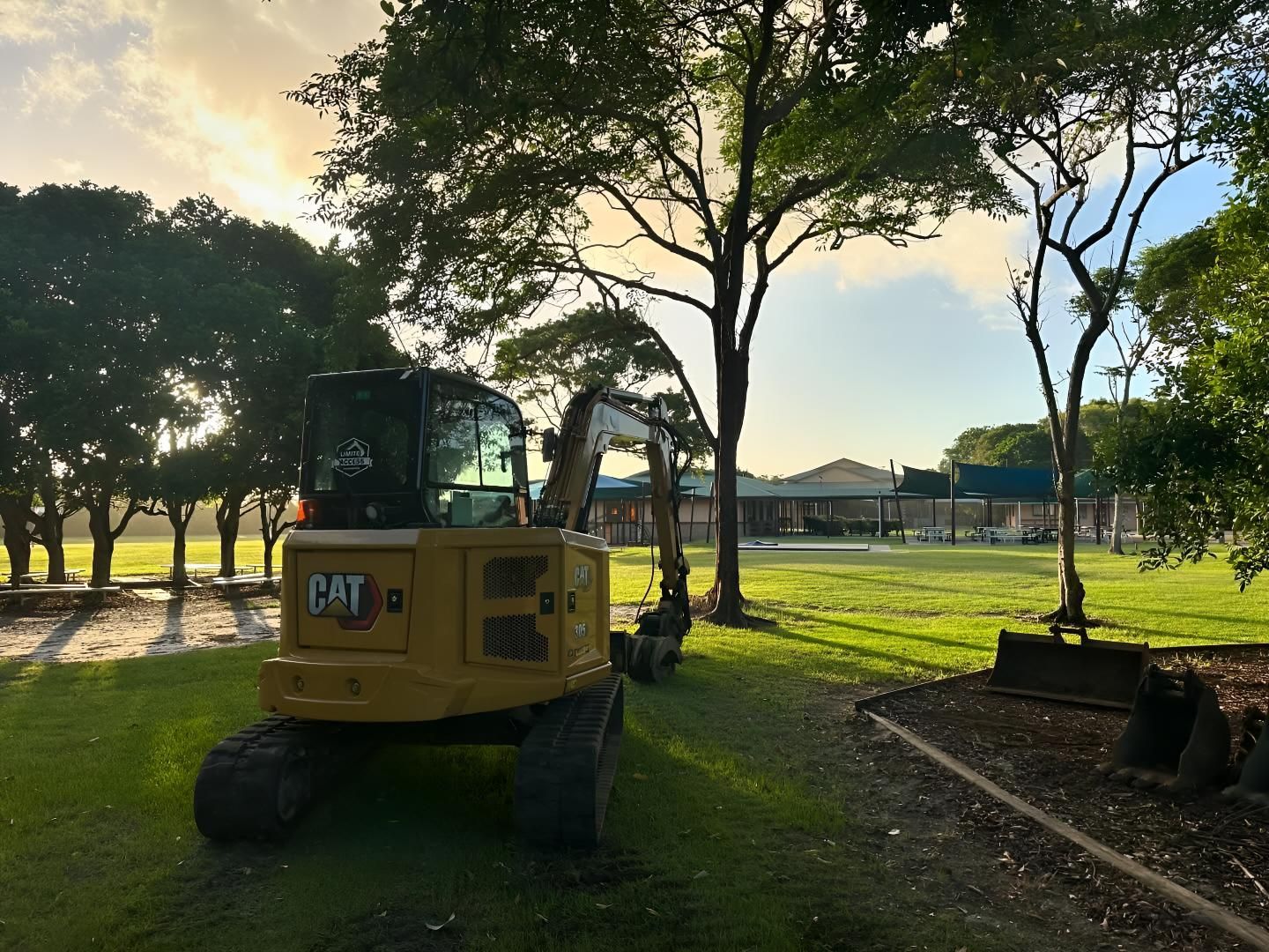 A Cat Excavator is Parked in a Grassy Field — Limited Access Excavation In Yamba, NSW