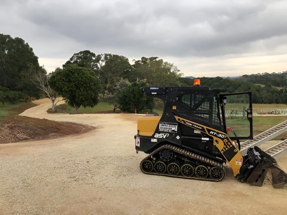 A Bulldozer is Parked on the Side of a Dirt Road — Limited Access Excavation In Mullumbimby, NSW