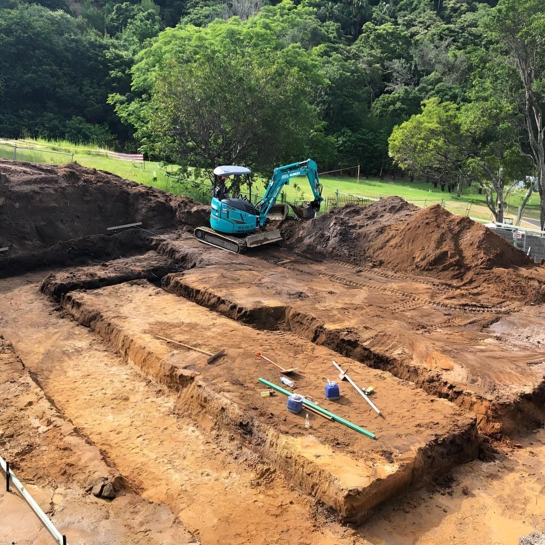 A Blue Excavator is Digging a Hole in the Dirt — Limited Access Excavation In Evans Head, NSW