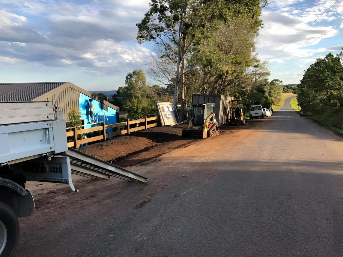 A Dump Truck is Parked on the Side of a Road Next to a Fence — Limited Access Excavation In Suffolk Park, NSW