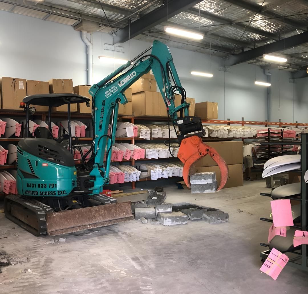 A Green Excavator is Sitting in a Warehouse — Limited Access Excavation In Ballina, NSW