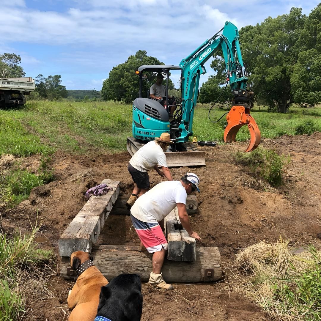 A Group of Men Are Working in a Field With a Bulldozer in the Background — Limited Access Excavation In Alstonville, NSW