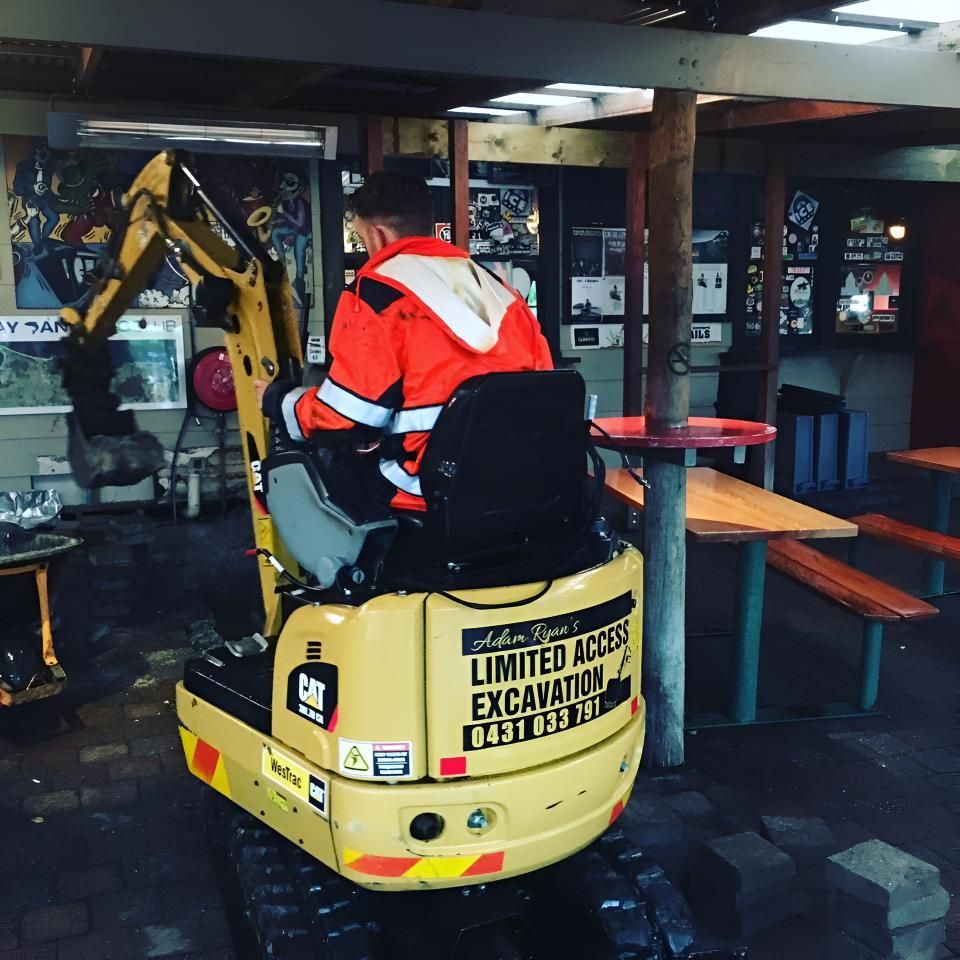 A Man is Riding a Small Excavator That Says Limited Access Excavation — Limited Access Excavation In Pottsville, NSW