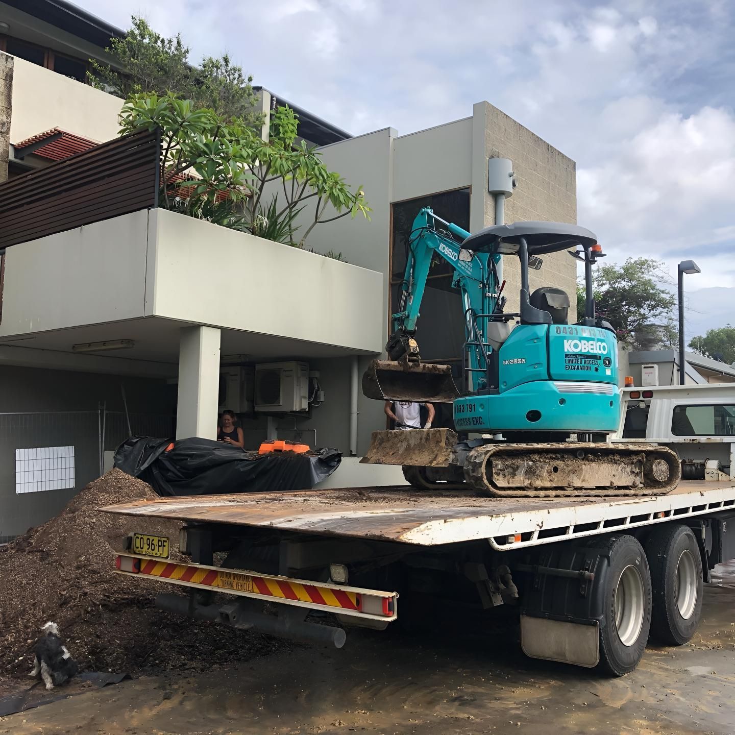A Blue Excavator is on the Back of a Flatbed Truck — Limited Access Excavation In Casino, NSW