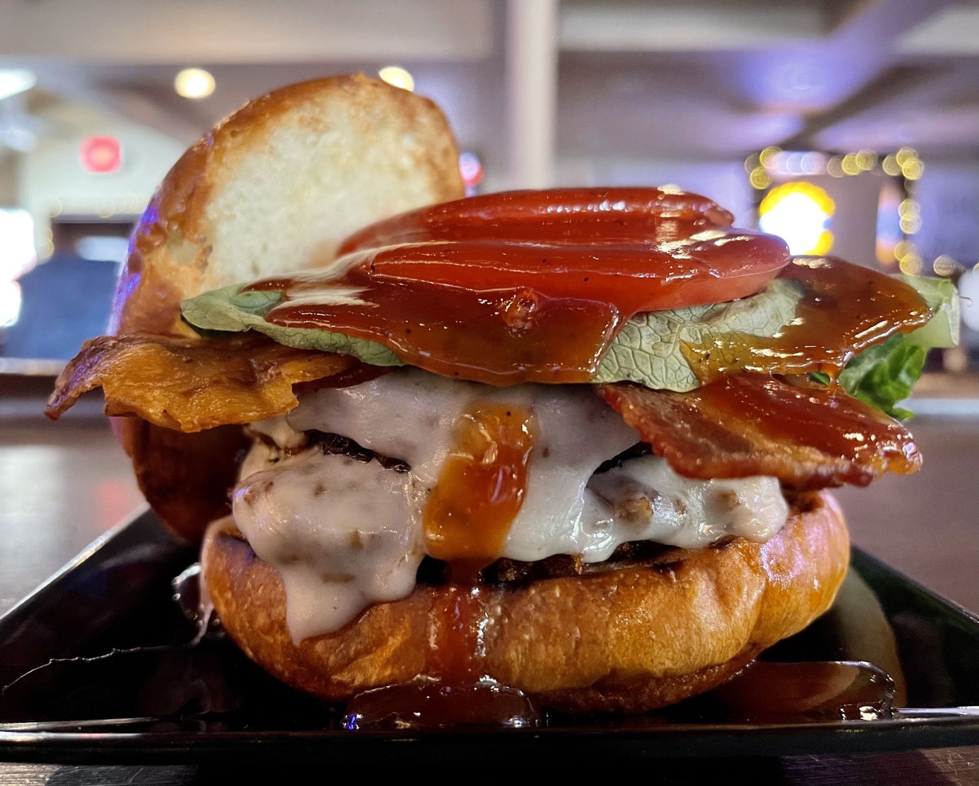 A close up of a hamburger on a plate on a table.