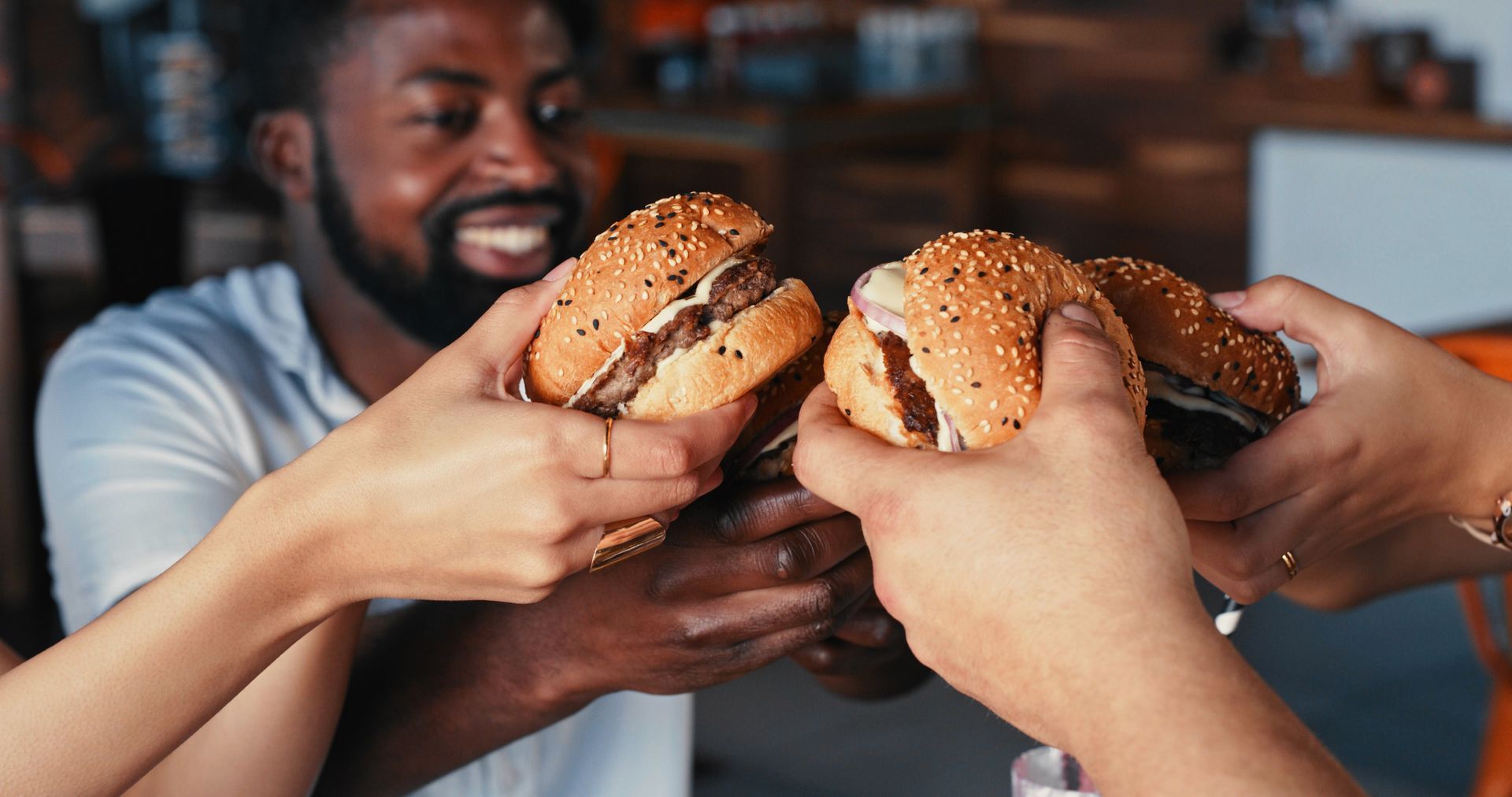 A group of people are eating hamburgers together in a restaurant.