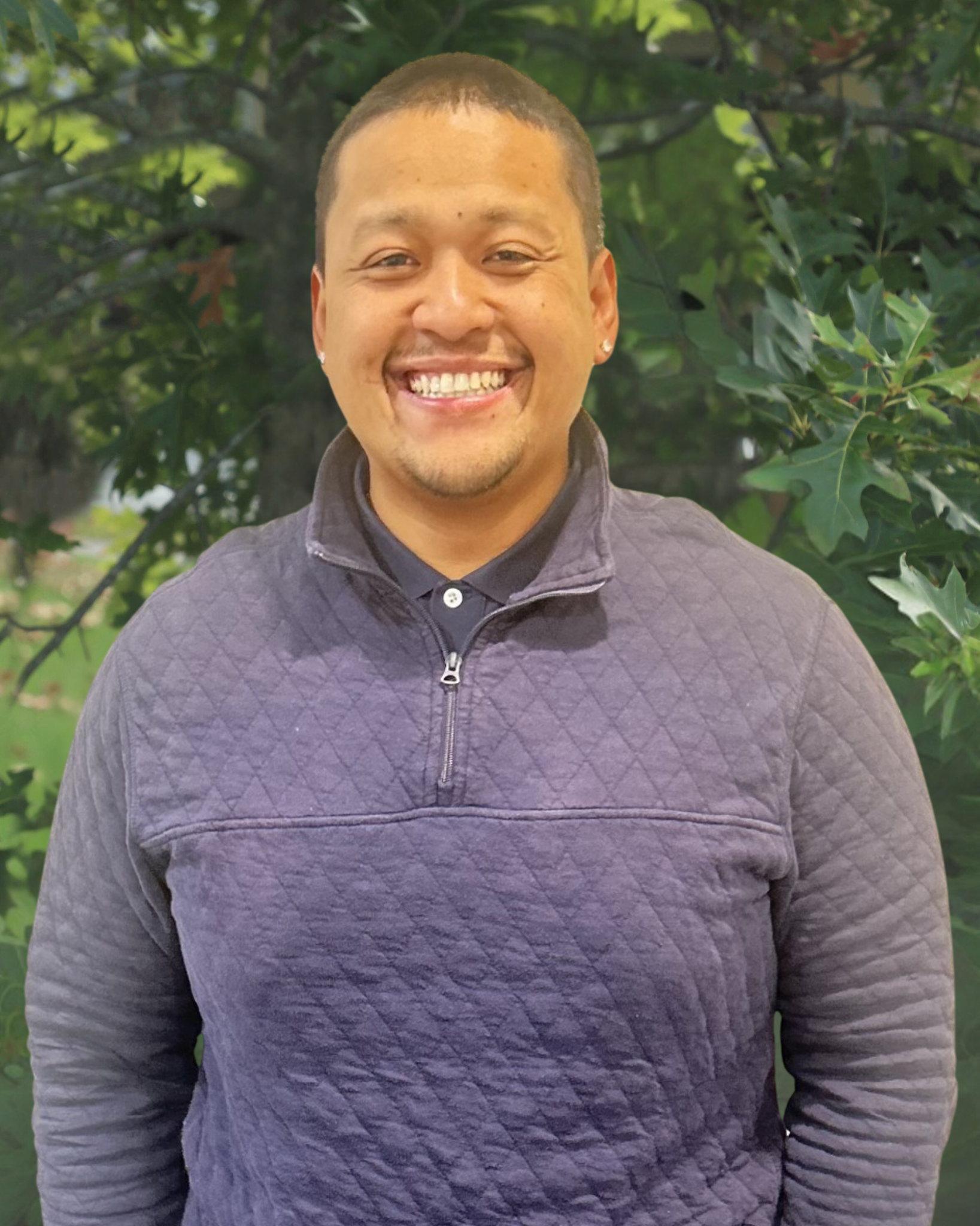 Woman with white hair, glasses, and black shirt smiling outdoors.