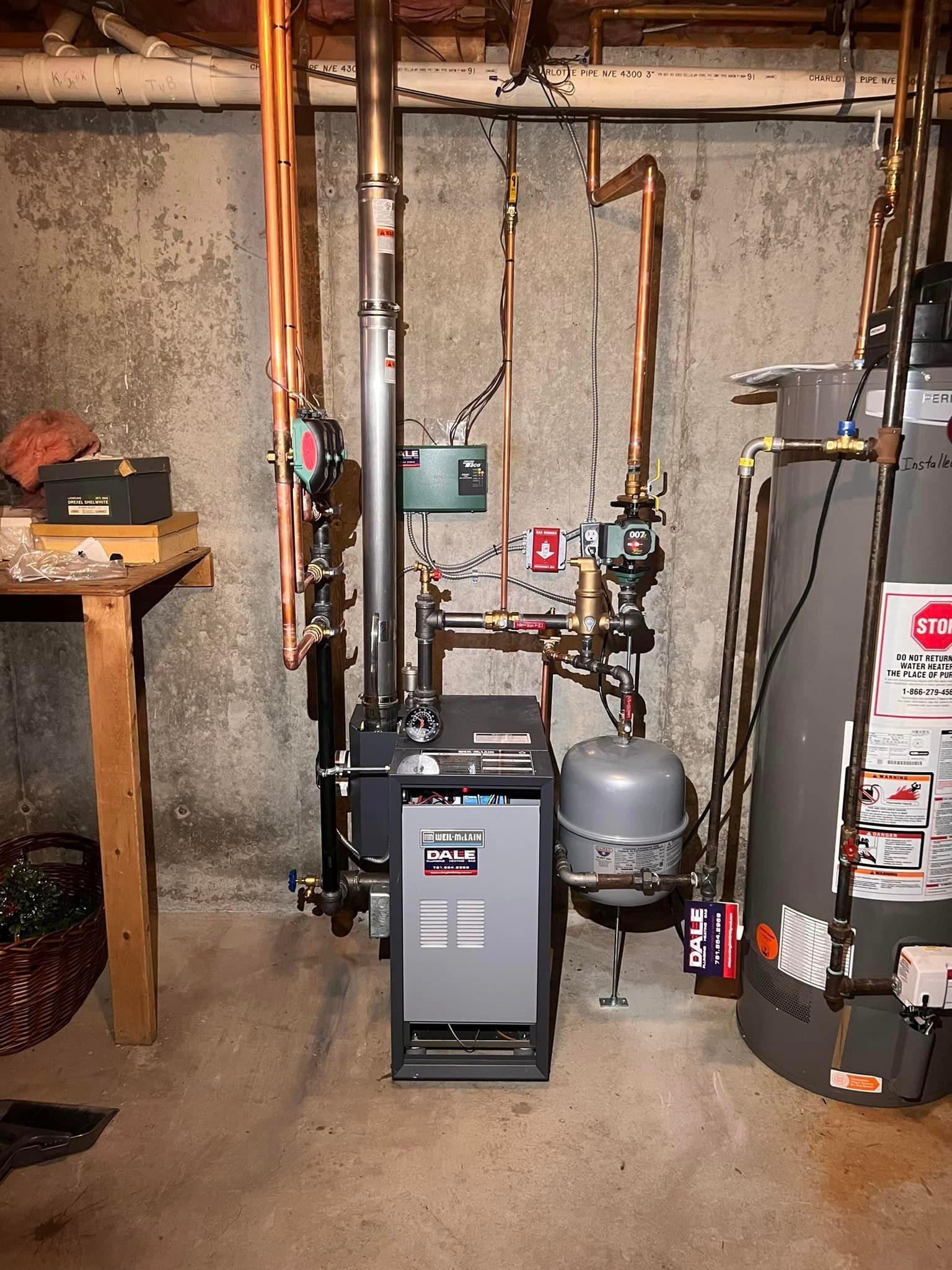 a boiler and a water heater are in a basement .