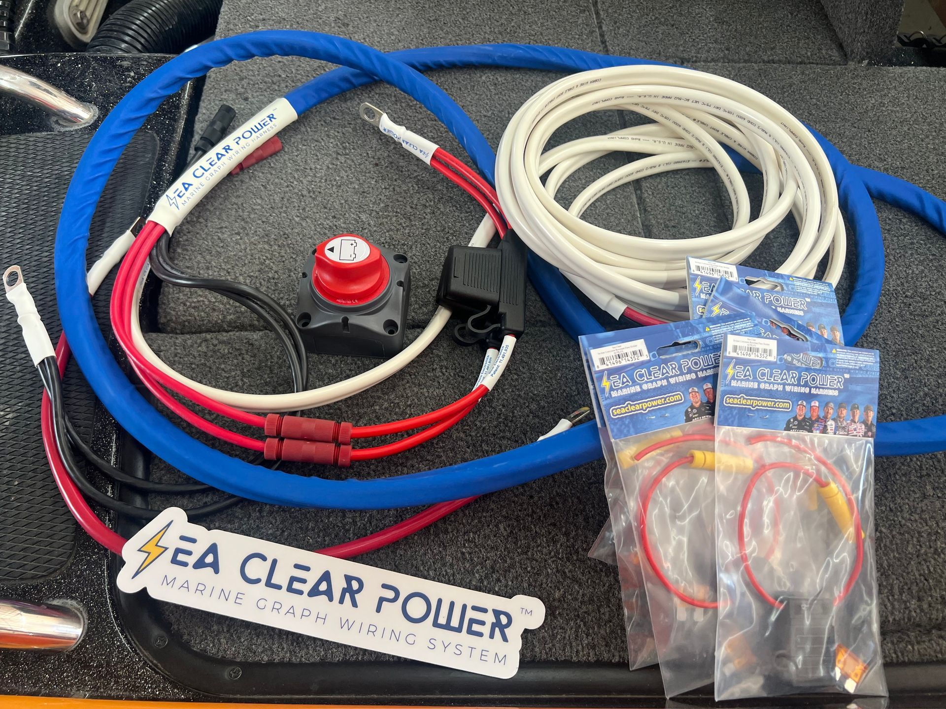 Boat electrical wiring kit with blue, white, and red wires, a power cutoff switch, and Sea Clear Power label.