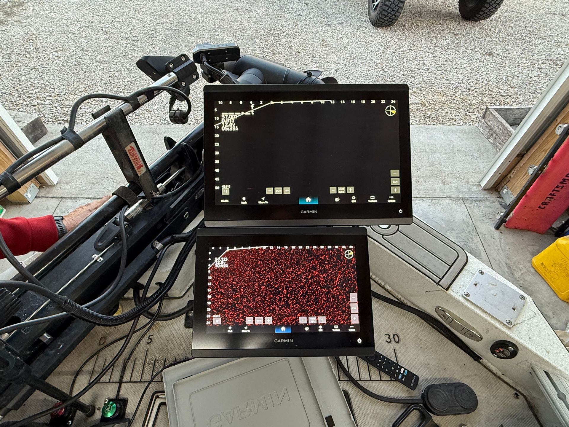 Two digital screens displaying data, one with a dark background and the other with a red pattern, mounted on a device with wires.
