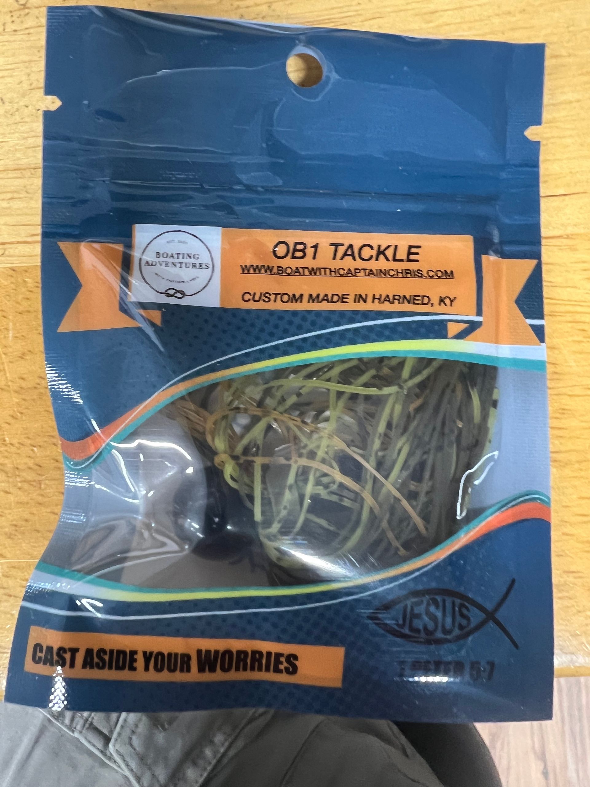 Rows of custom fishing lures in brown, green, and blue, displayed under 