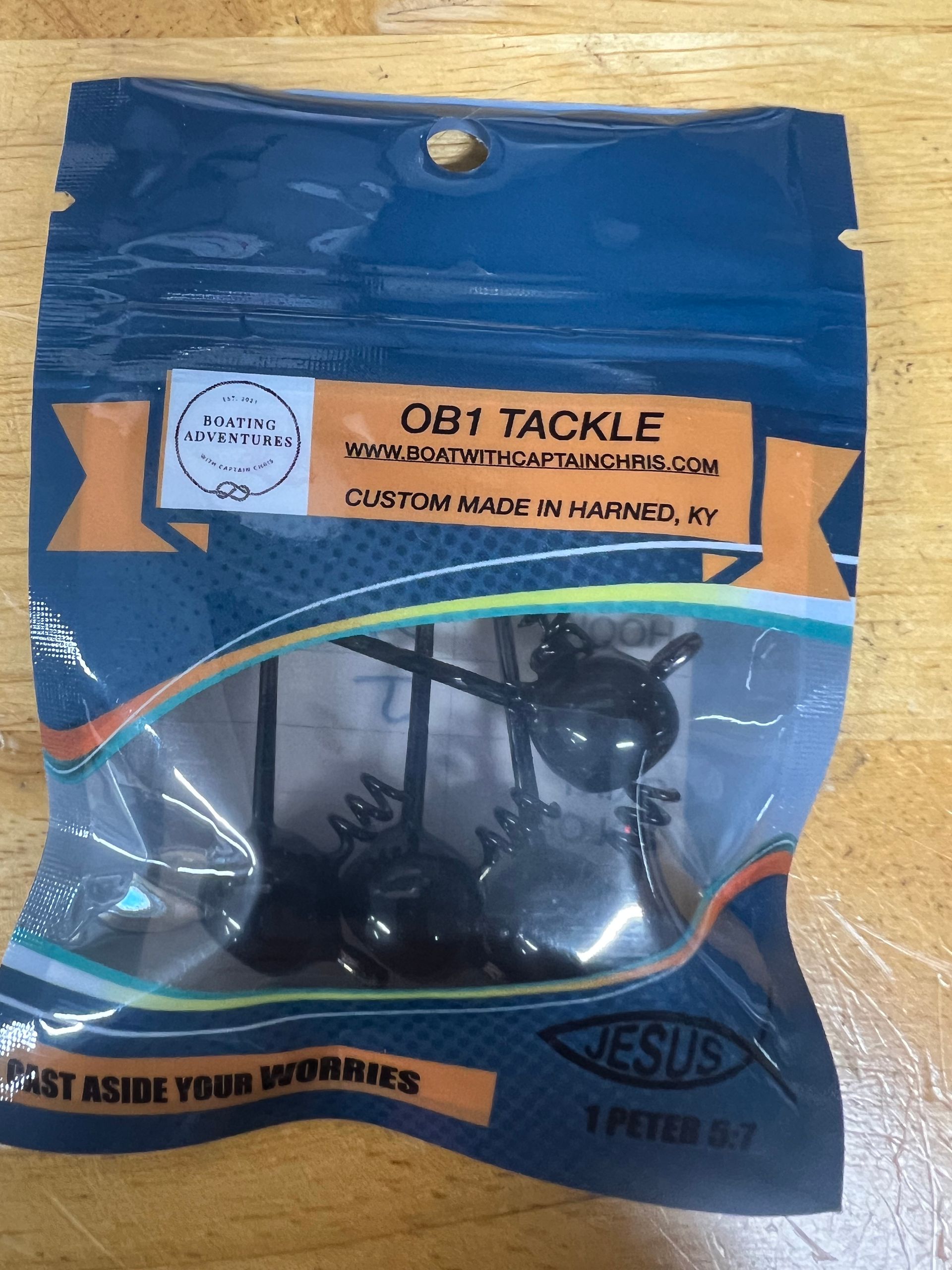 Rows of custom fishing lures in brown, green, and blue, displayed under 