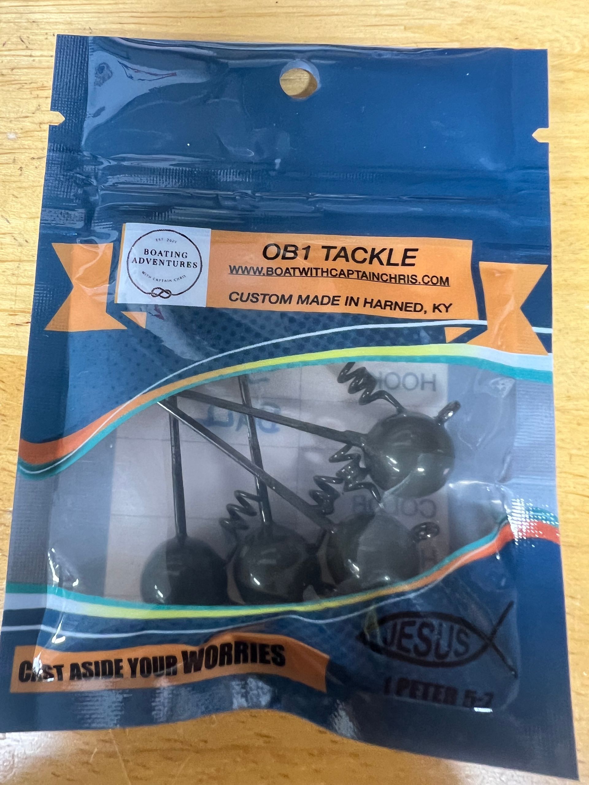 Rows of custom fishing lures in brown, green, and blue, displayed under 